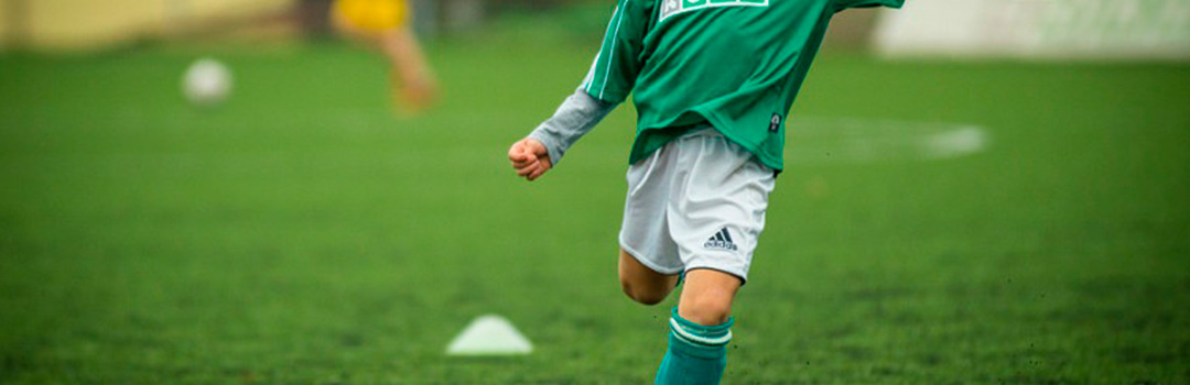 Niño jugando al fútbol dentro de un programa de integración social