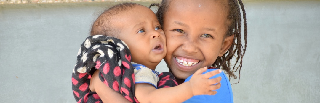 Niña y bebé sonriendo | malnutrición infantil